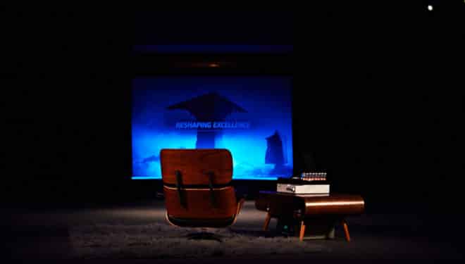 siège devant un écran cinéma où on peut lire Reshaping Excellence