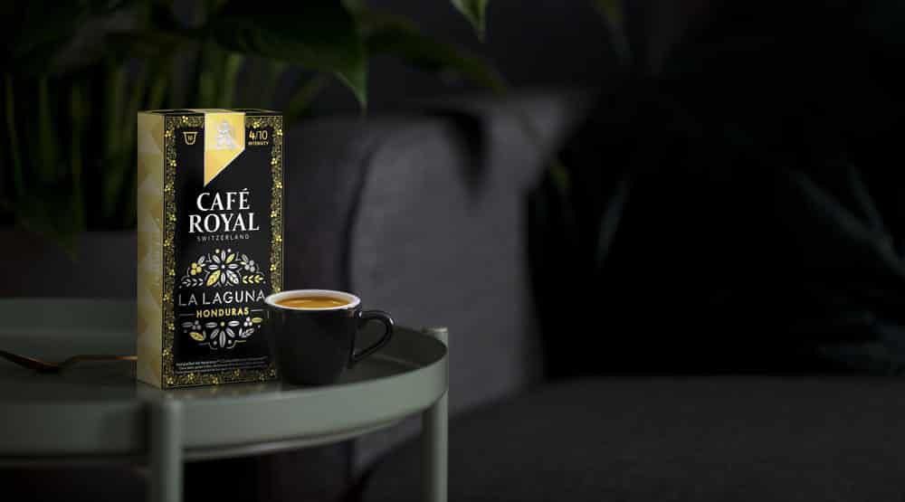 un paquet de Café Royal est posé sur une table à côté d'une tasse de café