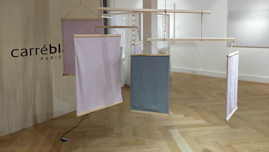 Des pans de tissus Carré Blanc sont exposés dans une salle