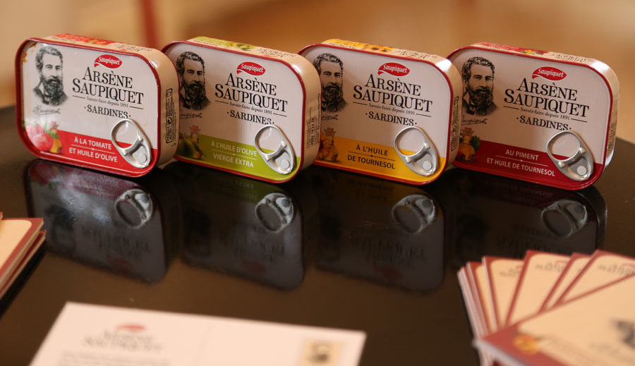 Quatre boites de sardines Saupiquet alignées sur une table